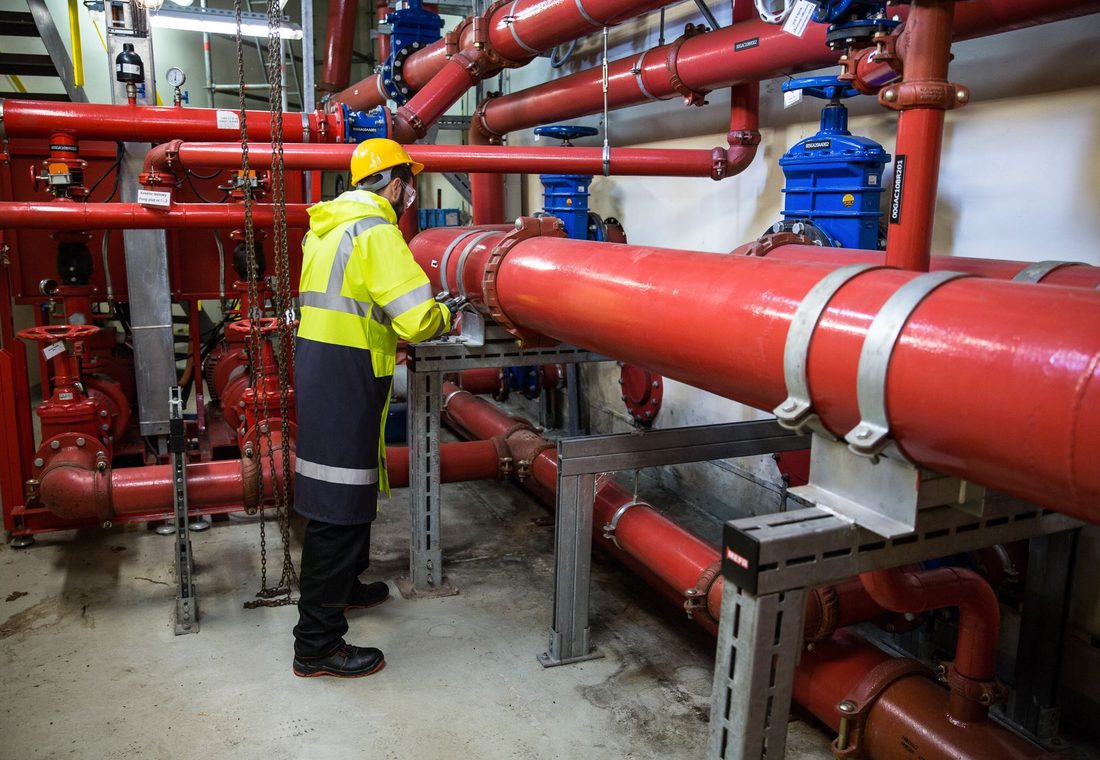 Plumber working on pipework under a sink